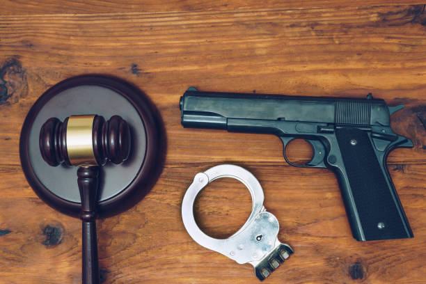 istock Judge gavel, handgun and handcuffs on wooden background 890668564