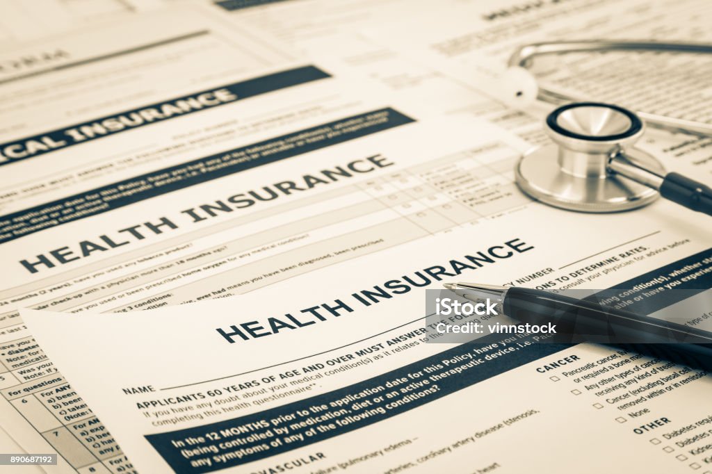 Health insurance questionnaire and registration concept. Blank health insurance forms with black premium pen and stethoscope. Medical information survey of insurance companies and agencies. Vintage and sepia photograph. Plan - Document Stock Photo