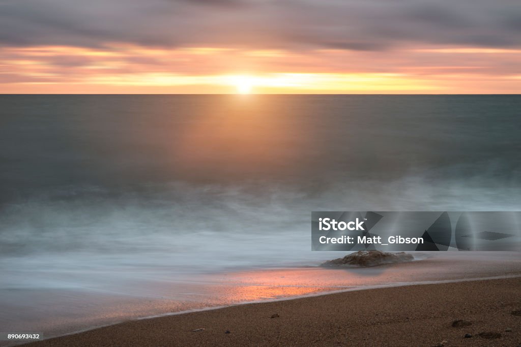 Beautiful vibrant sunset landscape image of Burton Bradstock golden cliffs in Dorest England Beautiful sunset landscape image of Burton Bradstock golden cliffs in Dorest England Beach Stock Photo