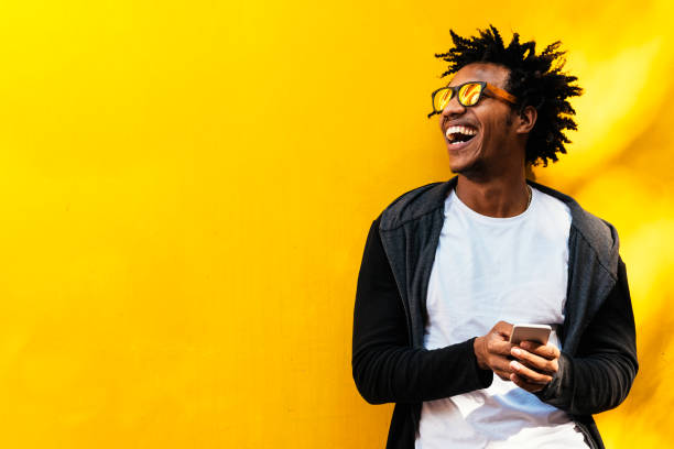 porträt von hübscher afro mann mit seinem handy. - afro frisur fotos stock-fotos und bilder