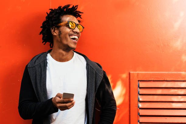 Afro young man using mobile phone. Afro young man using mobile phone in the street. hipster bike stock pictures, royalty-free photos & images