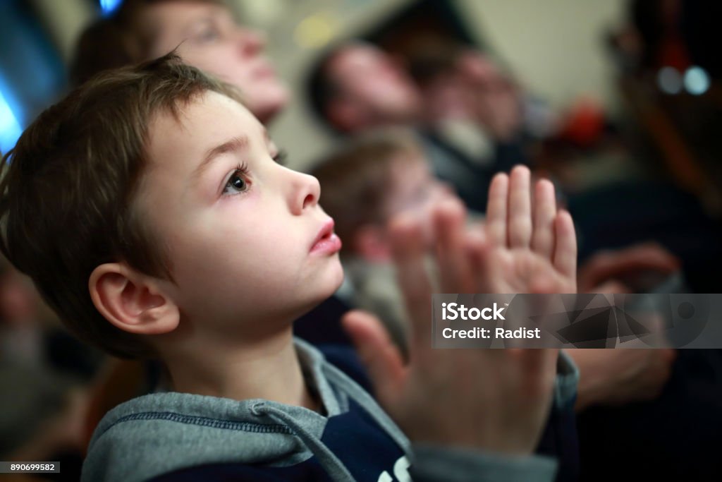 Boy applauding in theater Portrait of a boy applauding in theater Child Stock Photo