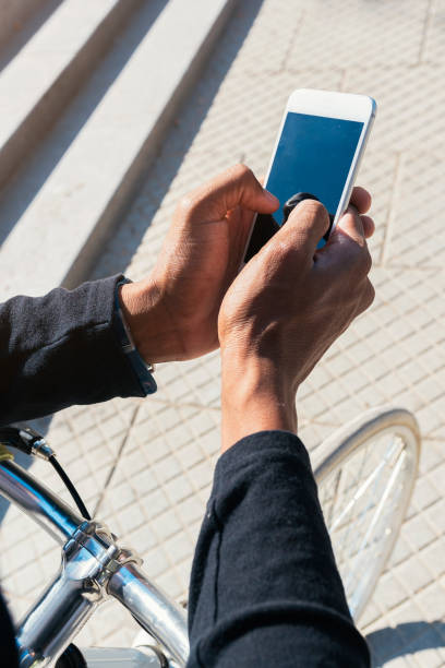 istock Close up of young man using mobile phone and fixed gear bicycle. 890702466