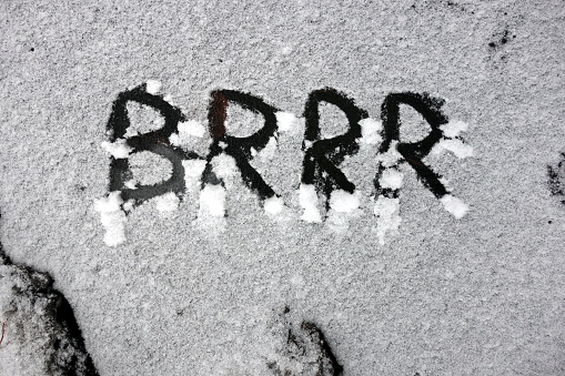 Word brrr written in snow on frozen water, severe winter