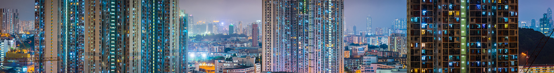 Panoramic view across the rooftops of Kowloon to the high density housing of high rise tower living in Hong Kong SAR, China.