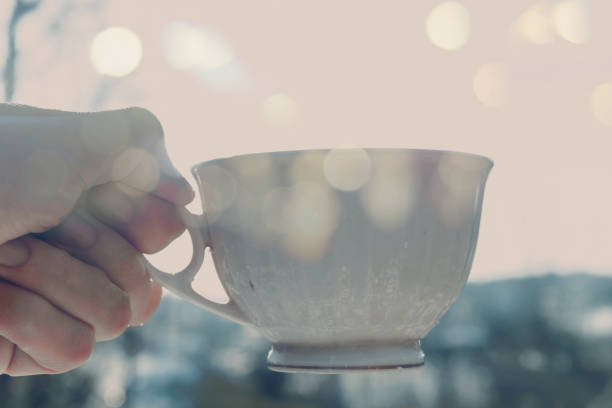 istock hand holding a cup of coffee or tea in the nature 890706898