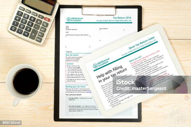 Uk Tax Form Sa100 With Filling Notes Over Office Table Stock Photo - Download Image Now