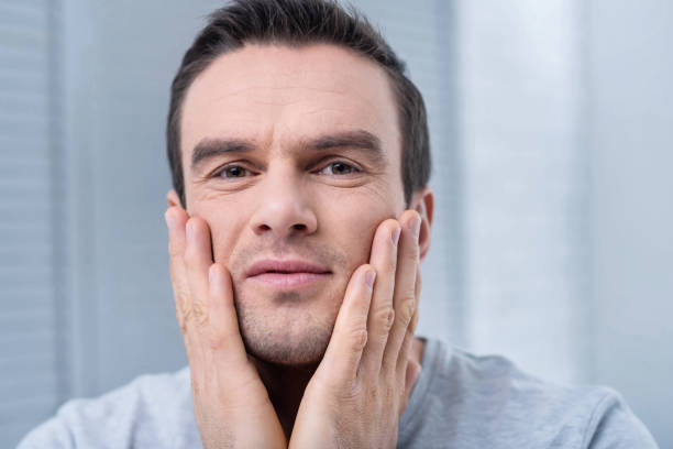 istock Young handsome man moisturizing his skin 890723426