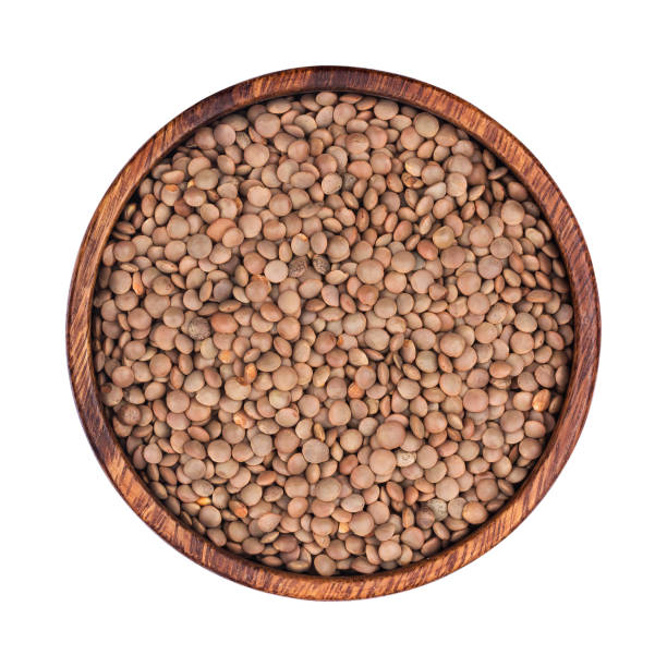istock Lentils in wooden bowl isolated on white background. Top view 890736568