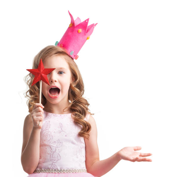 Little fairy girl in pink dress and crown with magic wand putting spell, isolated on white background