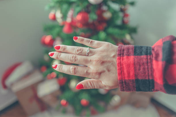 istock Female hand engagement ring and Christmas tree 890737214