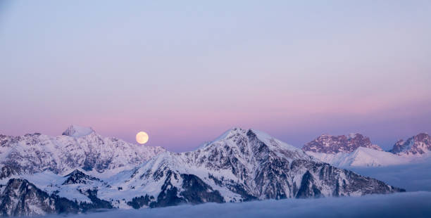full moon rising over a winter dream landscape in the Swiss Alps near Klosters in December