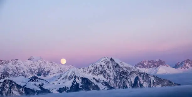 full moon rising over a winter dream landscape in the Swiss Alps near Klosters in December