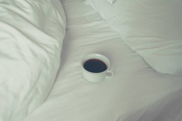 istock Cup of coffee on white bed 890744864