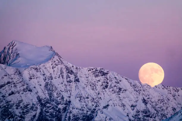 full moon rising over a winter dream landscape in the Swiss Alps near Klosters in December