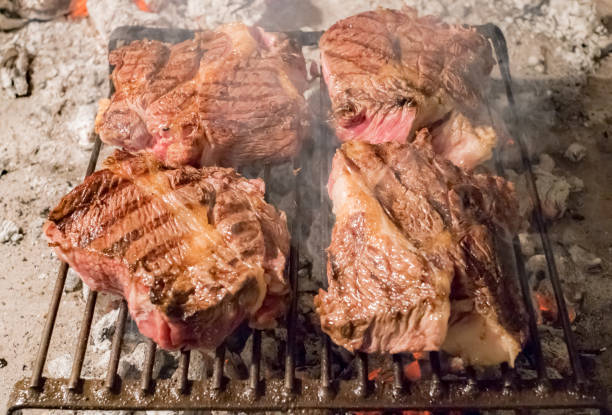 istock steak cooking on wood embers 890753092