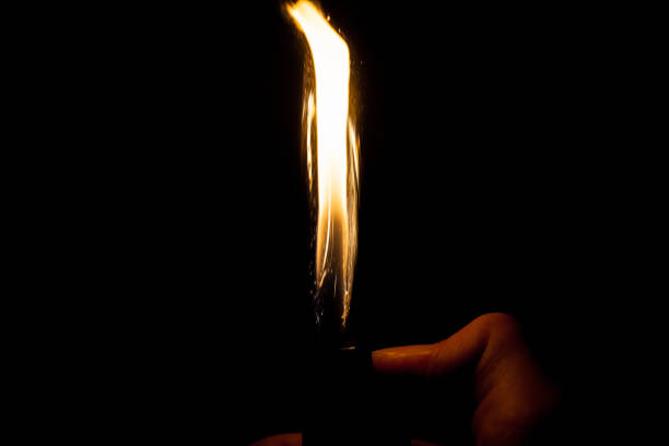 istock Close up view of real sparking light from lighter in dark black background 890757400