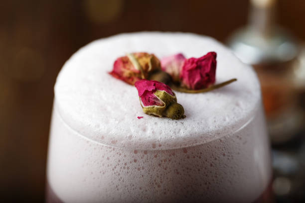 pink cocktail with foam, decorated with pink buds