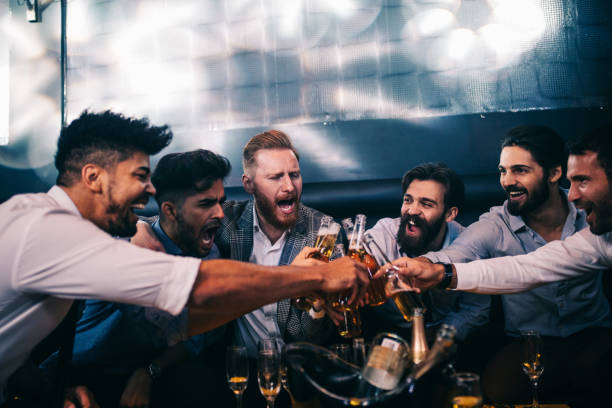 Enjoying their night out Group of young men toasting with beer at a nightclub drunk photos stock pictures, royalty-free photos & images