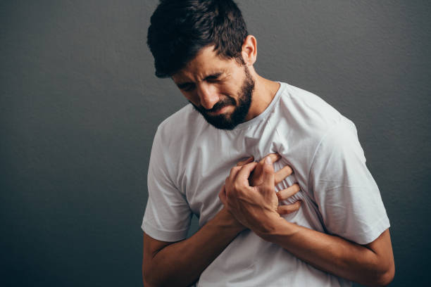 persone, assistenza sanitaria e concetto di problema - primo piano dell'uomo che soffre di dolore cardiaco su sfondo grigio - arresto cardiaco foto e immagini stock