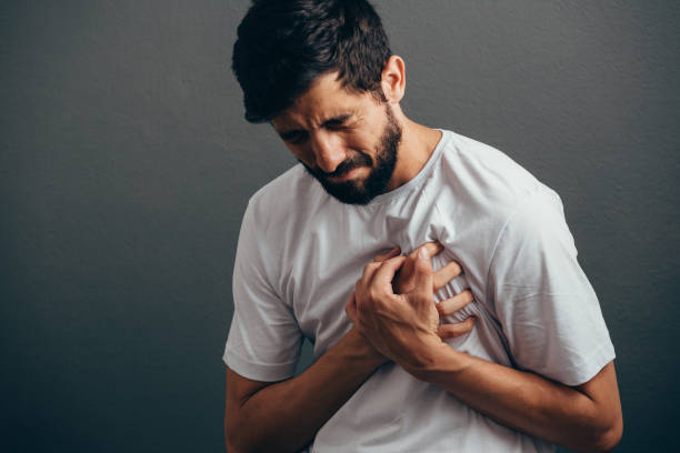 kişi, sağlık ve sorun kavramı - gri arka plan üzerinde kalp ağrısı acı adam yakın - kalp krizi stok fotoğraflar ve resimler