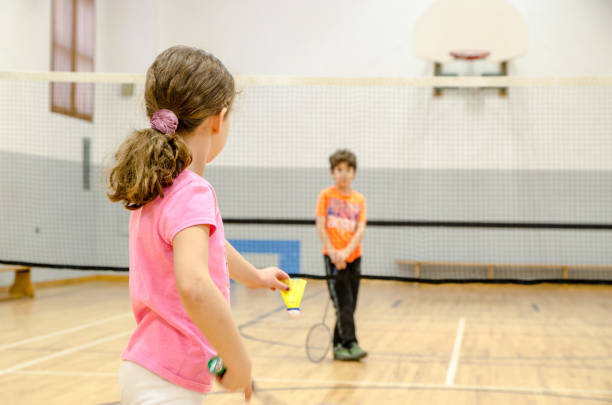 istock Two kids playing badminton in a gymnasium 890779620