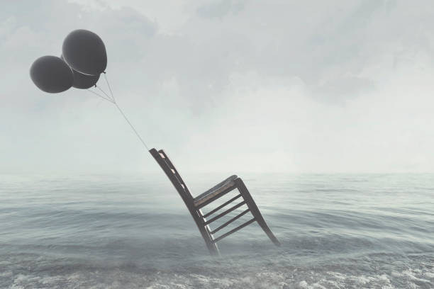 istock surreal image of a chair held in balance by flying balloons 890786830