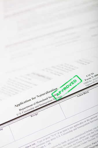 A stock photo of of the US Application for Naturalization form with a green \