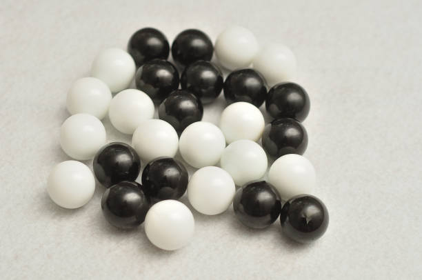 istock Black and white balls displayed on a white background 890787422