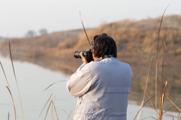 istock man photographs the lake 890790032