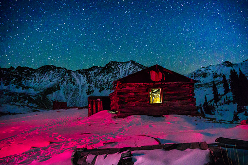 Old Abandoned Mining Buildings and Starry Milky Way Stars - Old cabins and night sky with stars and winter mountain view.