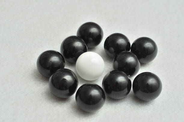 istock One white and a lot of black balls displayed on a white background 890790650
