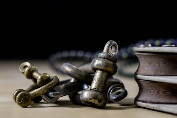 istock Rigging, sailing accessories. Rope block and shekel on a wooden table. Black background 890790844