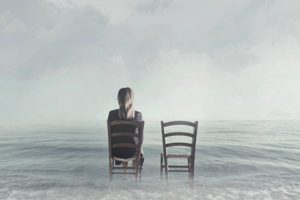 istock alone woman sitting next to her lover's empty chair 890793188
