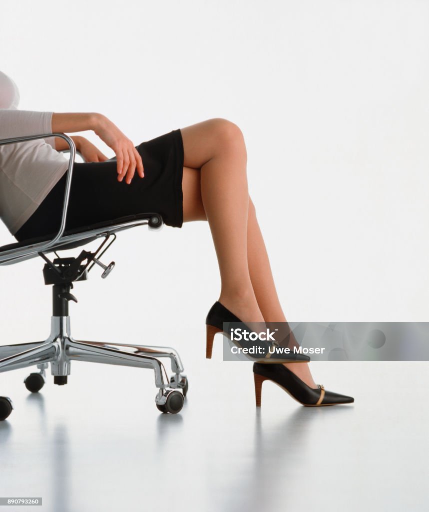 Business woman sitting in an armchair Business woman dressed with elegance sitting in an armchair, free space for text High Heels Stock Photo