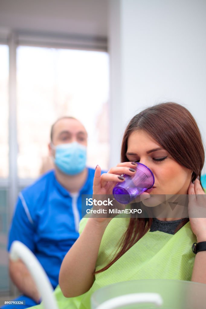 Washing mouth at dentist's office Young woman washing mouth at dentist's officeYoung woman washing mouth at dentist's office 20-29 Years Stock Photo