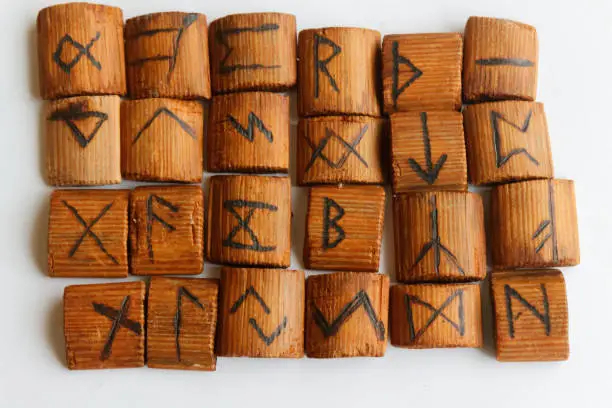 Photo of Wooden runes lie on a table on a white background