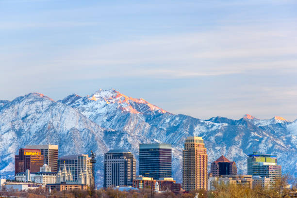 Salt Lake City with Snow Capped Mountain Sunset light hitting Salt Lake City and mountain range salt lake city utah stock pictures, royalty-free photos & images