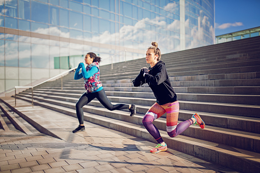 Runner girls are stretching on the stairs