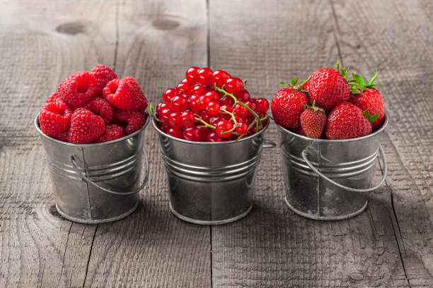 istock Berries in three metallic cans on old rustic wooden table 890796776