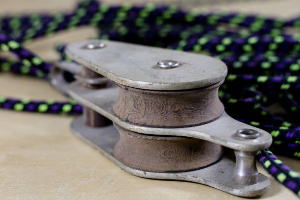 Rigging, sailing accessories. Rope block and shekel on a wooden table. Black background