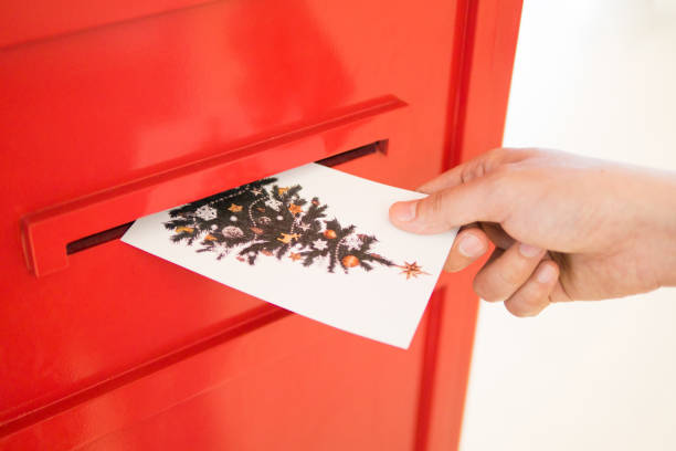 mão, soltando o postal de natal para caixa de correio vermelha enviando o desejo de natal para outras pessoas nos feriados sazonais - red asia send mail - fotografias e filmes do acervo