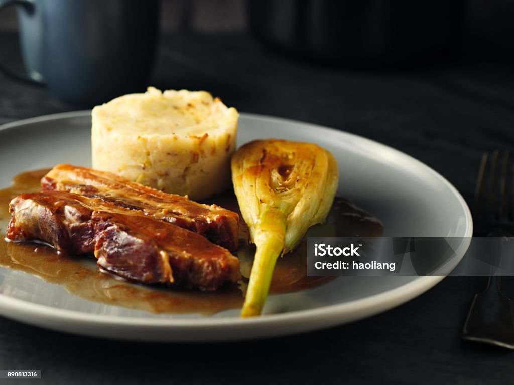 Panceta de cerdo con patatas hechas e hinojo estofado - Foto de stock de Alimento libre de derechos