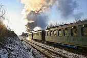 Beautiful old steam train with wagons running on rails at sunset. Excursions for children and parents on festive special days. Czech Republic Europe.
