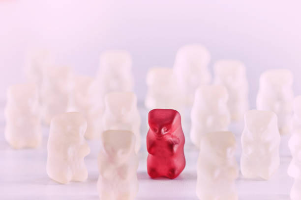 istock Red gummy bear candy standing out from the crowd arrangement close-up studio shot 890816150