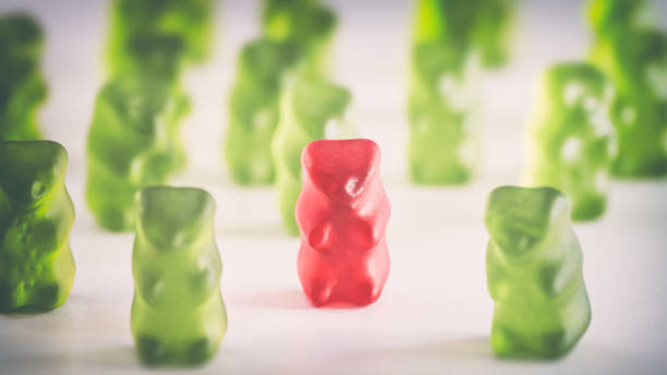 Colored gummy bear candy standing out from the crowd arrangement close-up studio shot