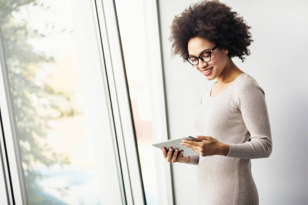 istock Young businesswoman working in modern office on a digital tablet 890830186