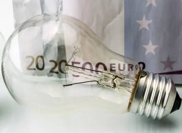 Photo of A lightbulb on euro bill, energy saving concept