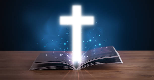 istock Open holy bible with glowing cross in the middle 890838042