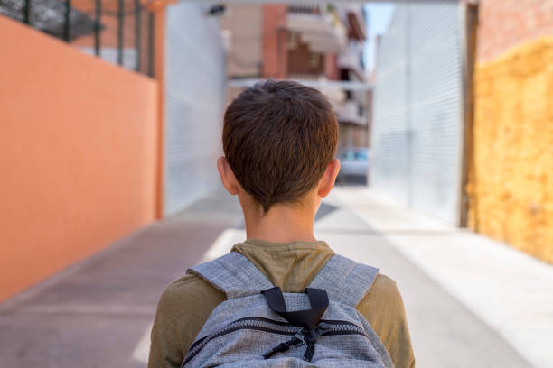 istock Teenage school boy with a backpack on his back walking to school 890847436